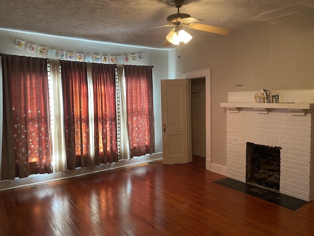 unfurnished living room with hardwood / wood-style floors, ceiling fan, a fireplace, and a textured ceiling