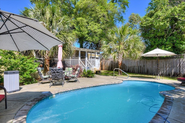 view of swimming pool with a sunroom and a patio