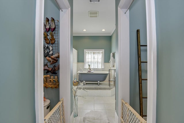 corridor featuring ornamental molding and light tile patterned floors