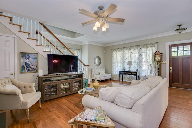 living room with hardwood / wood-style floors, ceiling fan, and crown molding