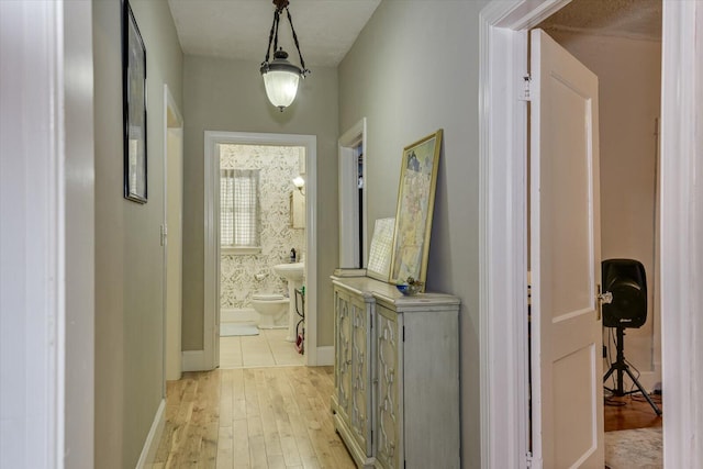 corridor featuring a textured ceiling and light wood-type flooring