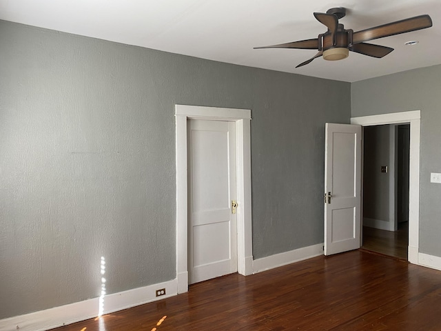 unfurnished bedroom with ceiling fan and dark hardwood / wood-style floors