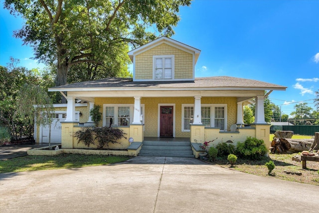 view of front of home with covered porch, an outdoor structure, and a garage