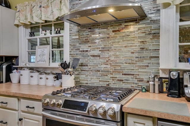 kitchen with white cabinets, decorative backsplash, stainless steel appliances, and range hood