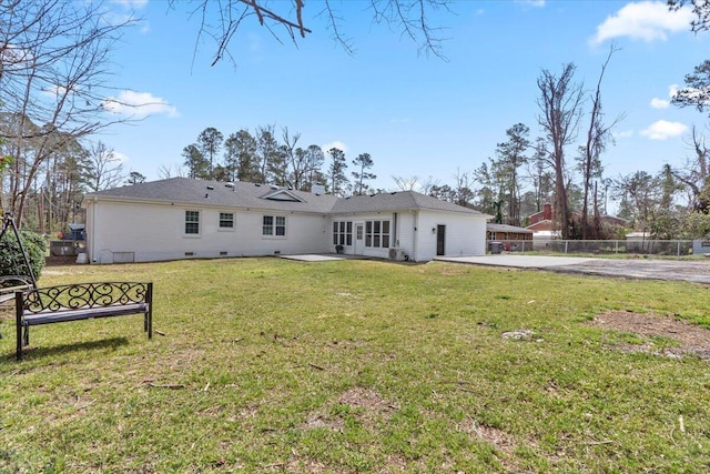 rear view of house with a patio, a yard, fence, and driveway