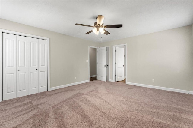 unfurnished bedroom with a closet, baseboards, carpet floors, and ceiling fan