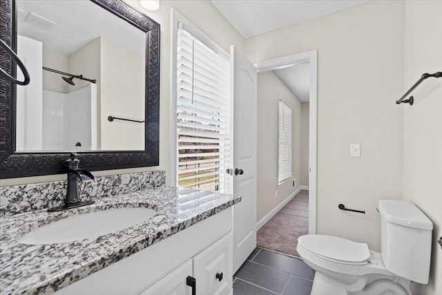 full bathroom with tile patterned flooring, walk in shower, baseboards, toilet, and vanity