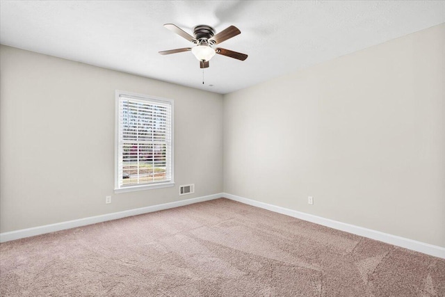 spare room featuring visible vents, baseboards, a ceiling fan, and carpet floors