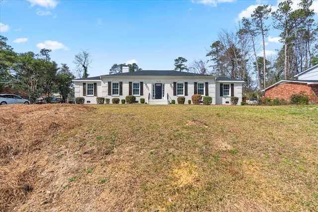 ranch-style house with a chimney and a front yard