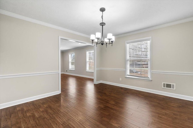 empty room featuring visible vents, ornamental molding, wood-type flooring, an inviting chandelier, and baseboards