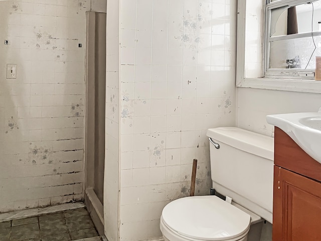 bathroom with brick wall, walk in shower, vanity, and toilet