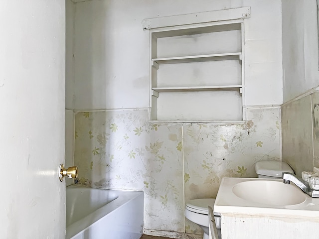 bathroom featuring toilet, vanity, and a bathtub