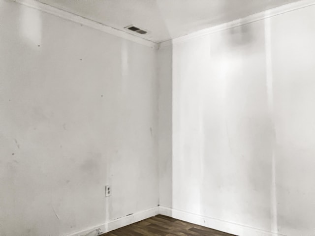 unfurnished room with dark wood-type flooring and crown molding