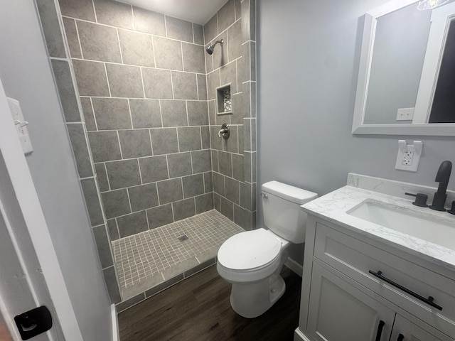 full bath featuring toilet, a shower stall, wood finished floors, and vanity