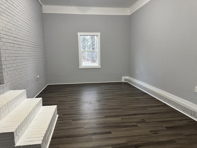 empty room with dark wood-type flooring and crown molding