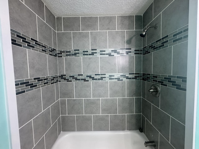 full bathroom with shower / bath combination and a textured ceiling