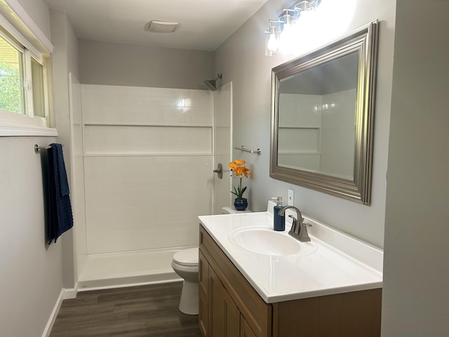 bathroom featuring a shower, hardwood / wood-style floors, vanity, and toilet