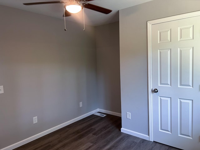 empty room featuring ceiling fan and dark hardwood / wood-style floors