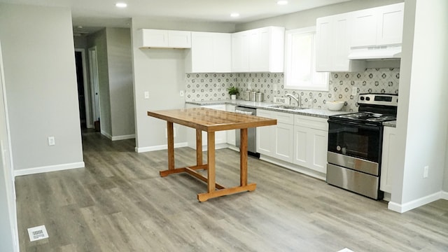 kitchen with white cabinetry, sink, stainless steel appliances, custom exhaust hood, and light wood-type flooring