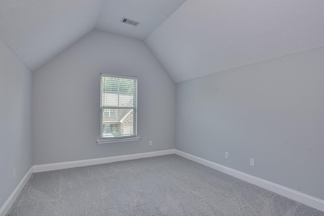 additional living space featuring carpet floors and vaulted ceiling