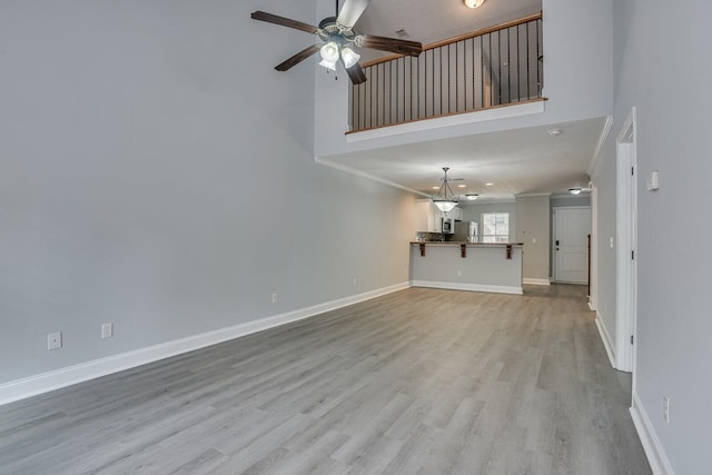 unfurnished living room featuring ceiling fan, light hardwood / wood-style floors, and crown molding