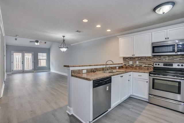 kitchen with white cabinets, sink, kitchen peninsula, and stainless steel appliances