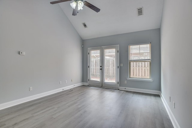 spare room with ceiling fan, french doors, high vaulted ceiling, and light wood-type flooring