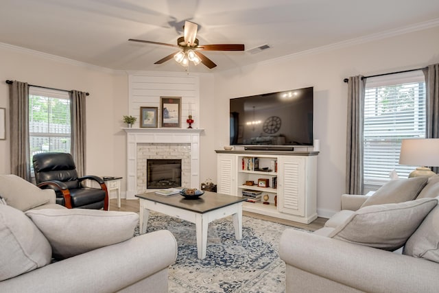 living room with crown molding, a ceiling fan, visible vents, and wood finished floors