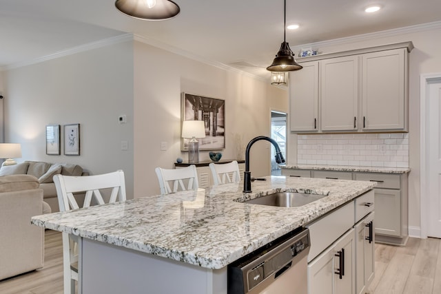 kitchen featuring dishwashing machine, crown molding, light wood finished floors, and a sink