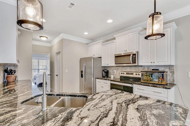 kitchen featuring white cabinetry, pendant lighting, stainless steel appliances, and dark stone counters