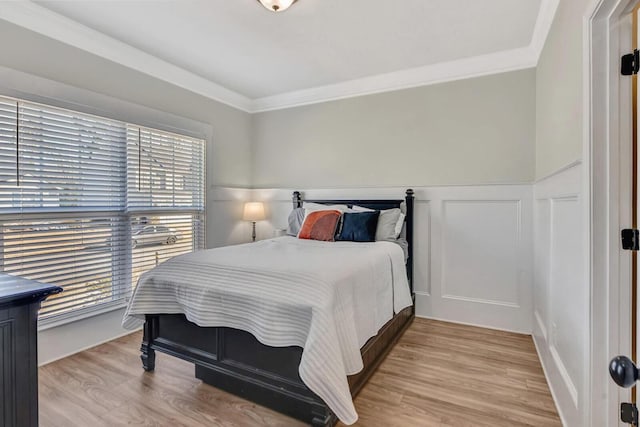 bedroom with ornamental molding and light hardwood / wood-style flooring