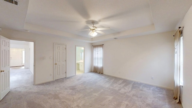 431 Connemara Trl, Evans, GA 30809 - unfurnished bedroom featuring a tray ceiling, light carpet, and multiple windows
