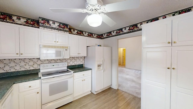 431 Connemara Trl, Evans, GA 30809 - kitchen with white appliances, dark countertops, light wood-type flooring, and white cabinets