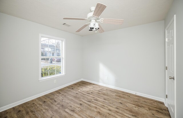 empty room with ceiling fan and hardwood / wood-style floors