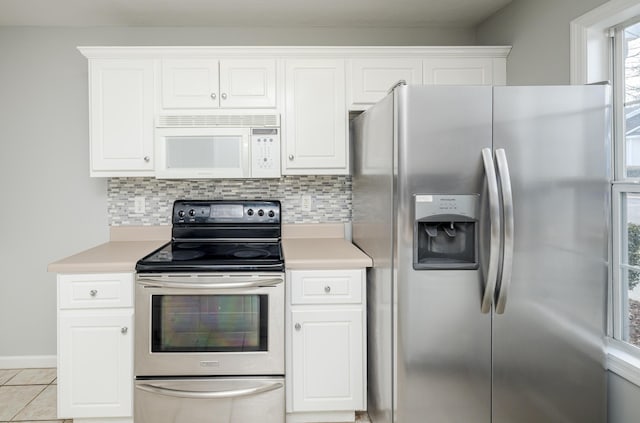 kitchen with tasteful backsplash, white cabinetry, light tile patterned flooring, and appliances with stainless steel finishes