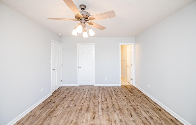 unfurnished bedroom with ceiling fan and light hardwood / wood-style floors