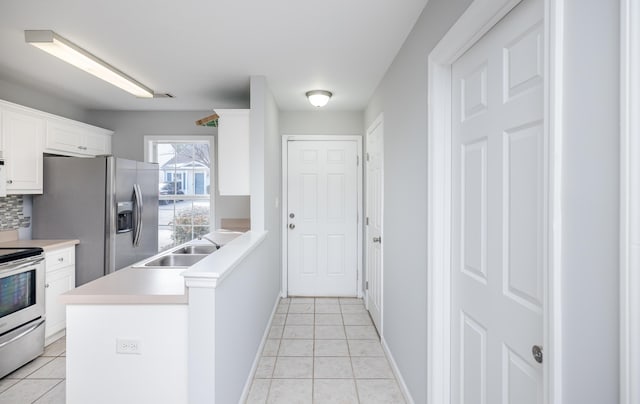 kitchen featuring stainless steel appliances, light tile patterned flooring, sink, and white cabinets