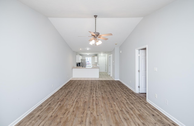 unfurnished living room featuring ceiling fan, lofted ceiling, and light hardwood / wood-style floors