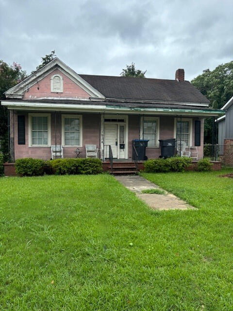 1924 Fenwick St, Augusta, GA 30904 - view of front of home with a porch, brick siding, a chimney, and a front yard