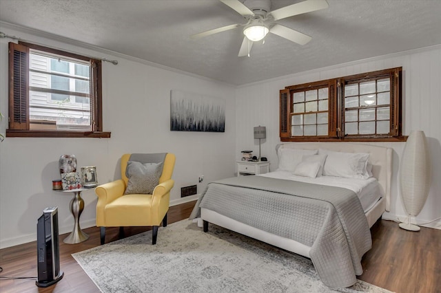 bedroom featuring a textured ceiling, ceiling fan, wood-type flooring, and crown molding