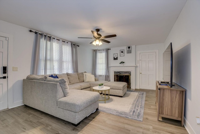 living room with ceiling fan, hardwood / wood-style floors, a high end fireplace, and plenty of natural light