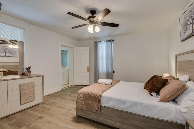 bedroom with ceiling fan, light wood-type flooring, and ensuite bath