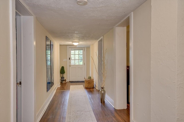 doorway featuring a textured ceiling and dark wood-type flooring