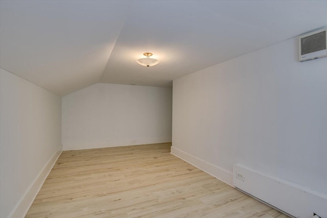 bonus room with light hardwood / wood-style floors and vaulted ceiling