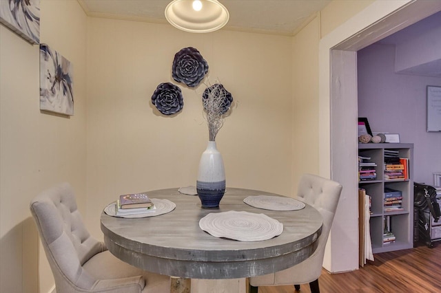 dining area with dark hardwood / wood-style floors and crown molding