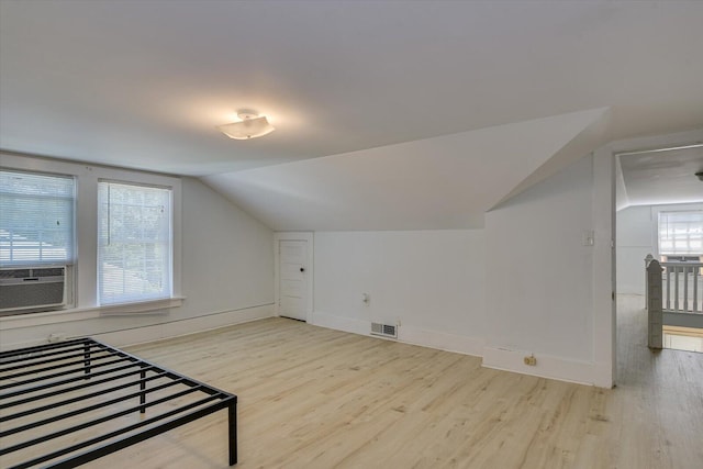 bonus room with light hardwood / wood-style flooring, cooling unit, and lofted ceiling