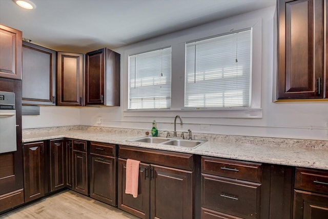 kitchen featuring dark brown cabinetry, sink, plenty of natural light, and light wood-type flooring