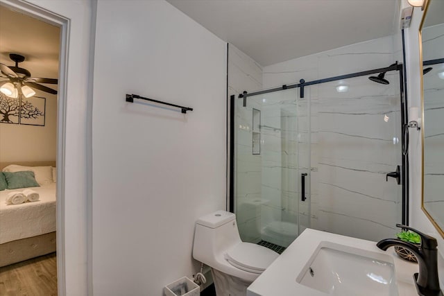 bathroom with ceiling fan, sink, wood-type flooring, an enclosed shower, and toilet