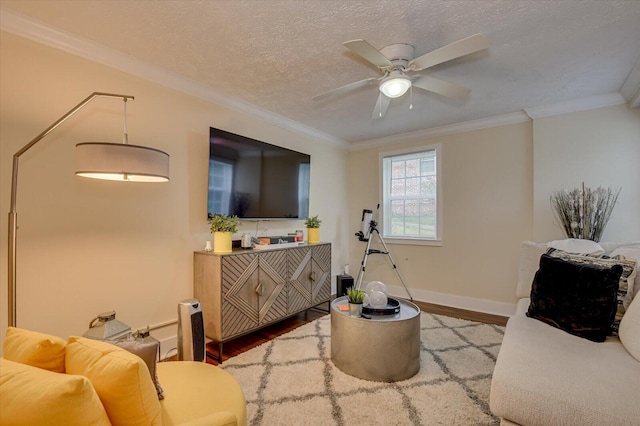 living room featuring ceiling fan, hardwood / wood-style floors, a textured ceiling, and ornamental molding