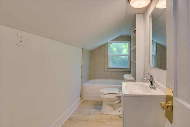 bathroom featuring vanity, vaulted ceiling, hardwood / wood-style floors, toilet, and a bathing tub